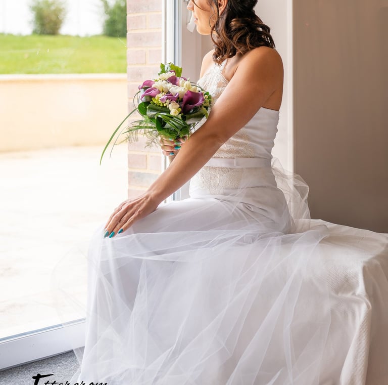 a bridesmaid sitting on a bench in a window