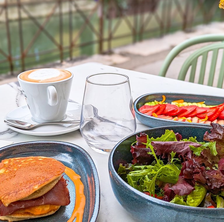 une table avec brunch au bord du Lac d'Annecy avec café, fruits frais, pancakes