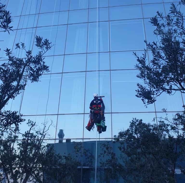a man in a suit is cleaning a glass building