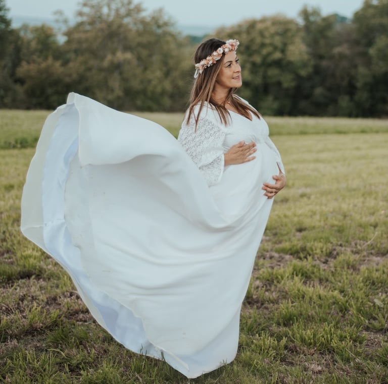 a pregnant woman in a white dress with a flower crown