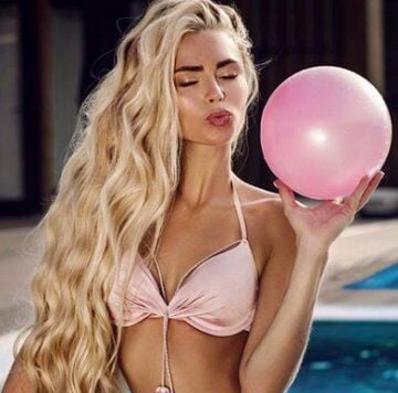 a woman in a bikini top and a pink balloon