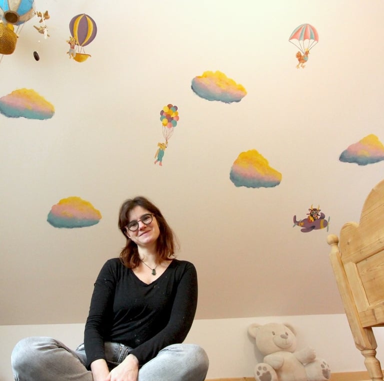 artiste Marie Hardy devant peinture murale en couleurs chambre enfant Aunay sur Odon Caen Normandie