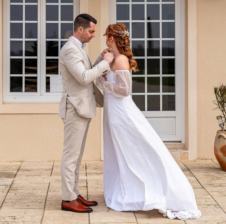 a bride and groom standing in front of a house
