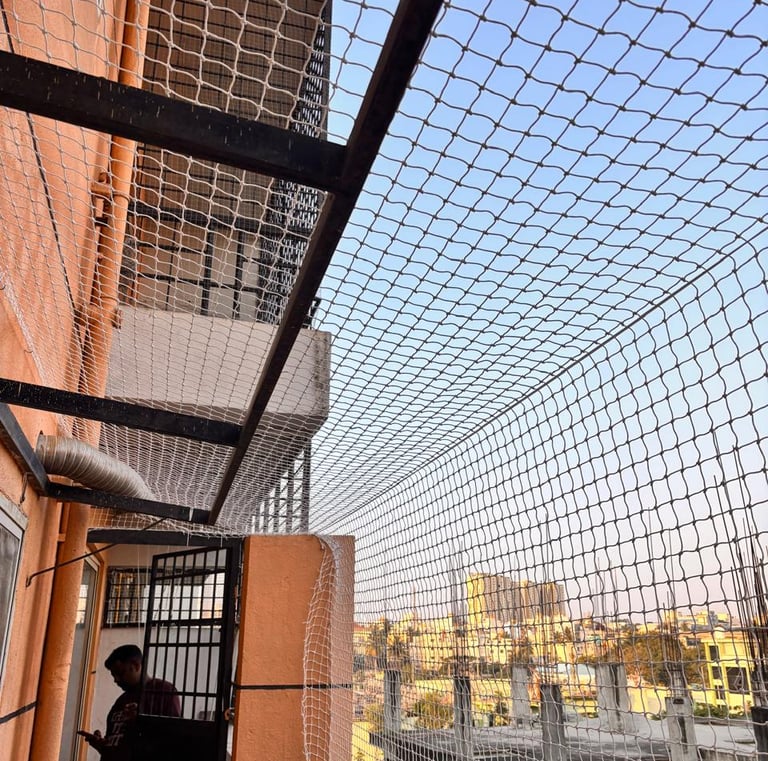 Technician from Sukumari Safety Nets carefully measuring a balcony frame before installation.