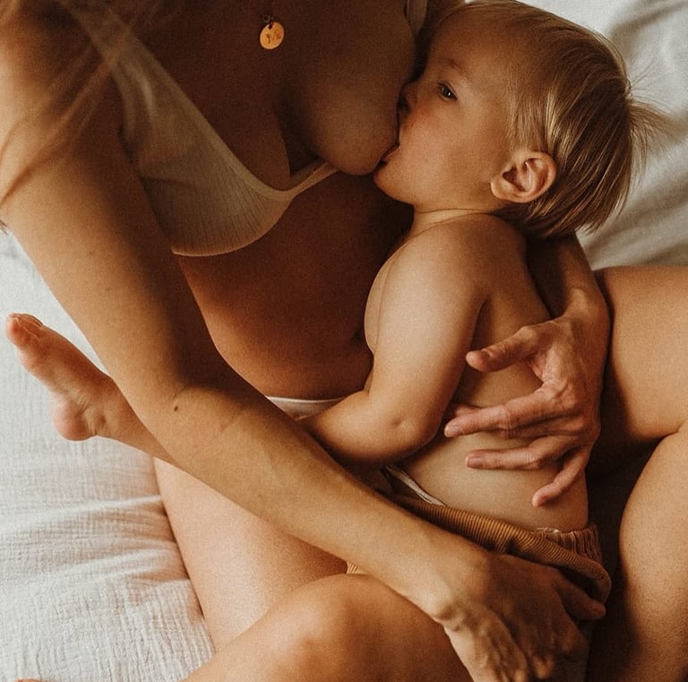 bébé qui tete au sein de maman dans le lit