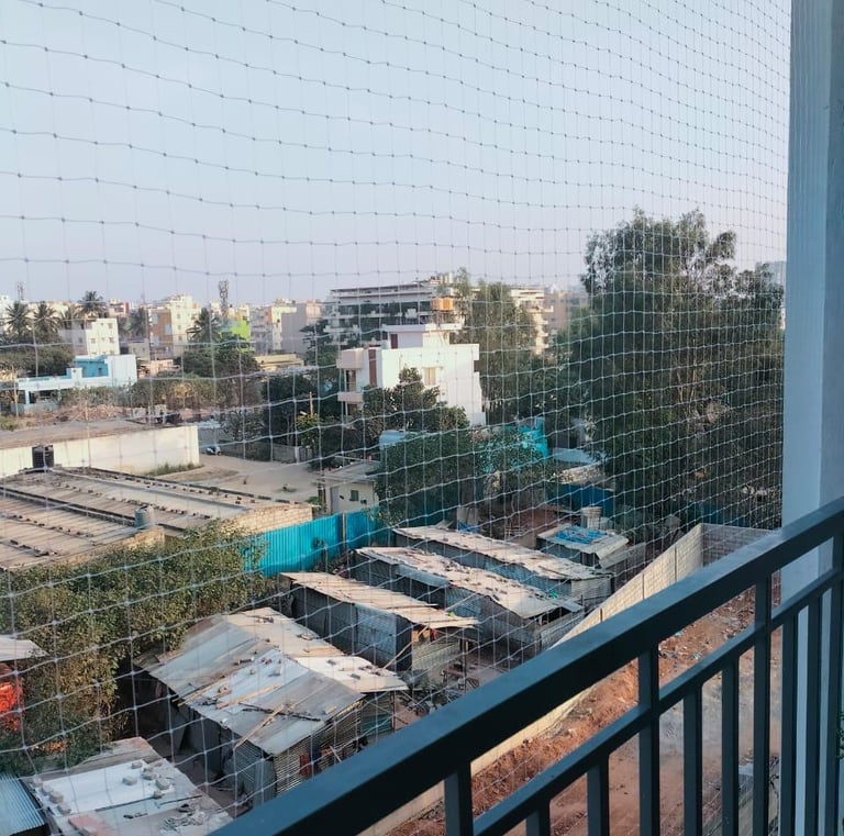 Close-up of a sturdy anti-pigeon net installed on a balcony railing.