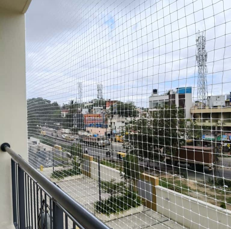 Team from Arjilli Enterprises fitting a balcony safety net with precision.