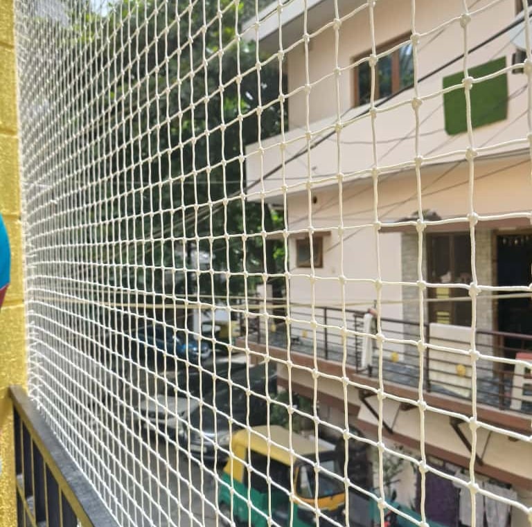 Child playing safely behind a balcony net installed by Arjilli Enterprises.