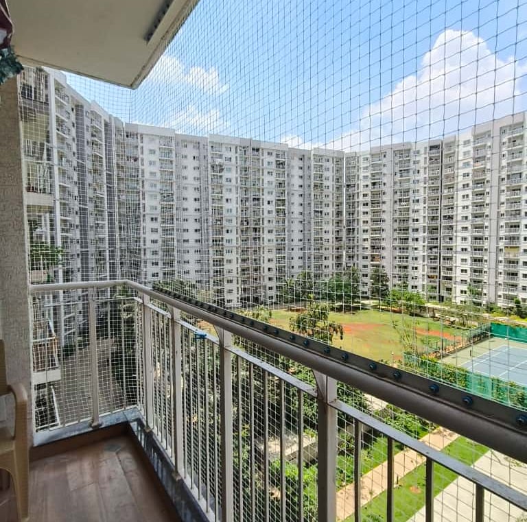 Evening view of a balcony secured with a tightly woven safety net.