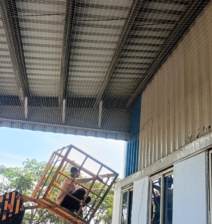Close-up of sturdy pigeon netting securely installed over a warehouse entrance.