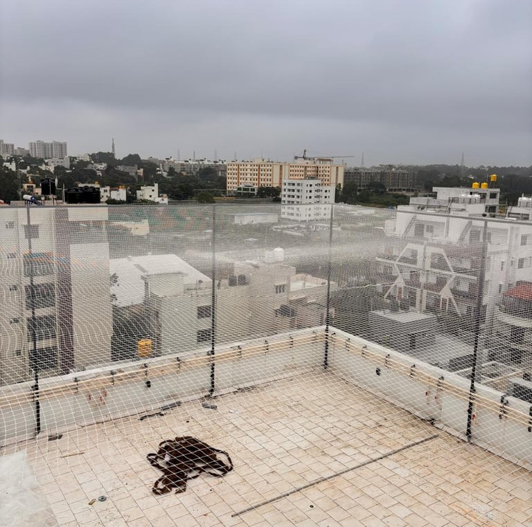 A freshly installed terrace sports net protecting a rooftop cricket pitch in Chennai under bright su