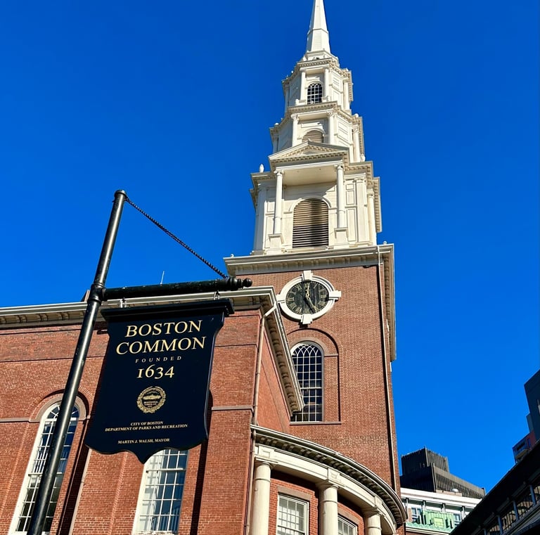 A sign advertising Boston Commons in front of Park Street Church