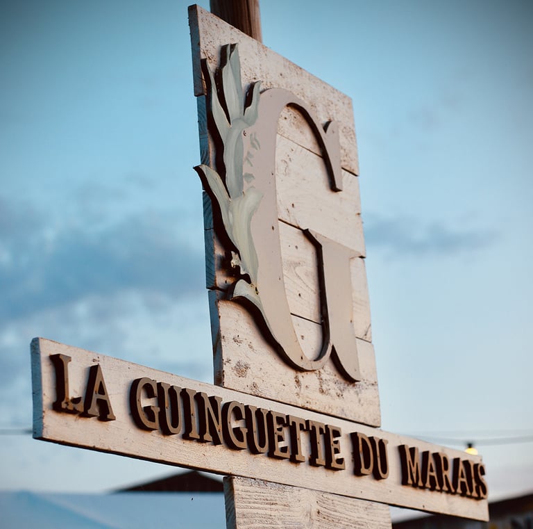 Photo d'un panneau en bois de l'entrée de la Guinguette des marais à Batz sur Mer