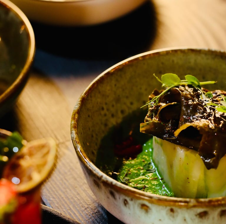 Gros plan d'un bol avec un plat de poisson et d'algues et une sauce épaisse verte