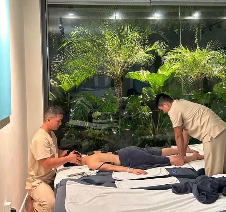 two men massaging a women in massage room