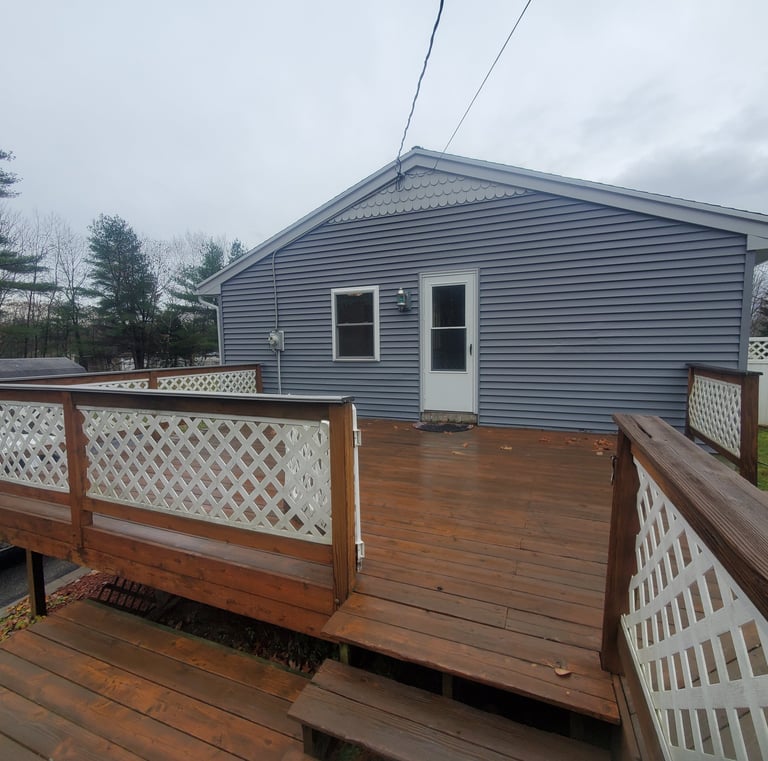a house with a deck and a white truck parked in front of it