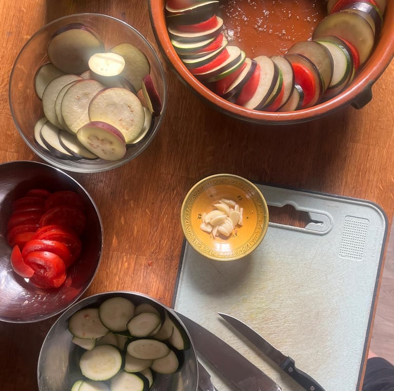 a table with bowls of sliced vegetables and a knife