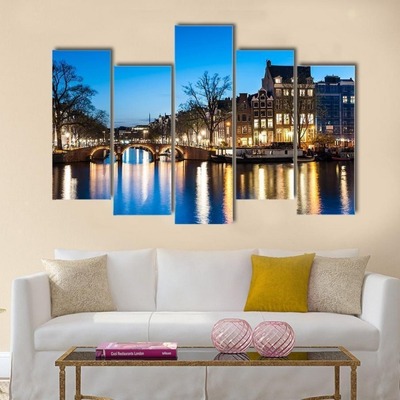 Five-panel canvas print of a lit bridge and buildings reflecting on a canal, mounted above a white c
