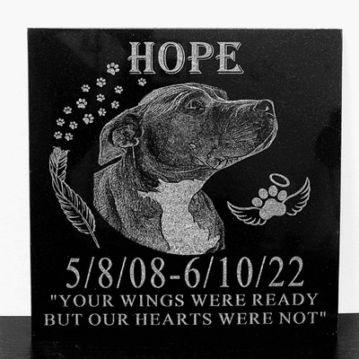 Laser-engraved granite plaque with a portrait of a dog named Hope and the text 'Your wings were read