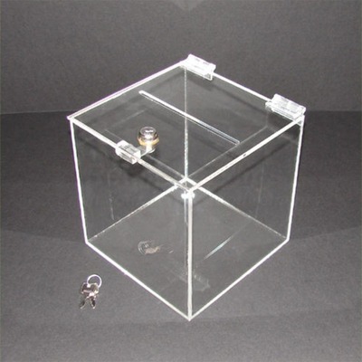 Acrylic suggestion box with a key lock and keys beside it.