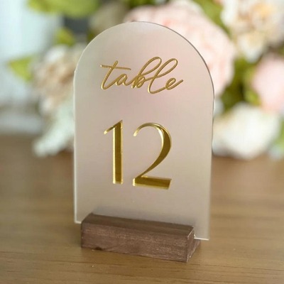 Clear acrylic table number 12 with gold text and a wooden base.
