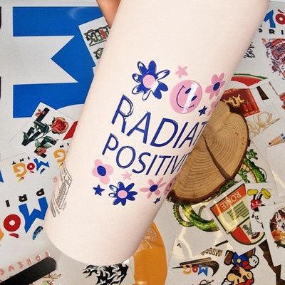 "Radiate Positivity UV DTF transfer sticker applied to a white bottle.