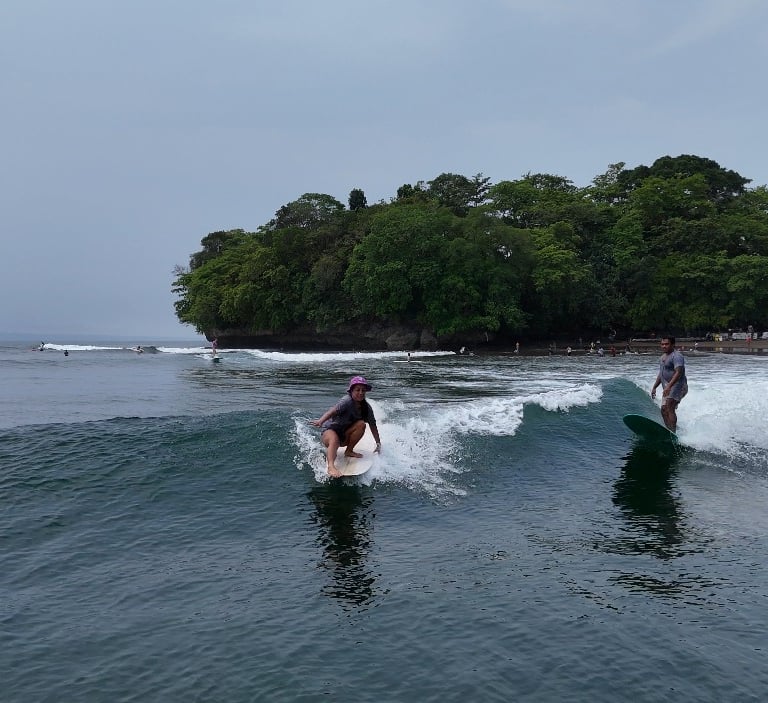 Ucup coaching longboard with student in Batukaras at main point break