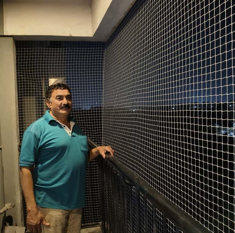 Completed balcony net protecting plants and pets on a cozy Bangalore balcony.