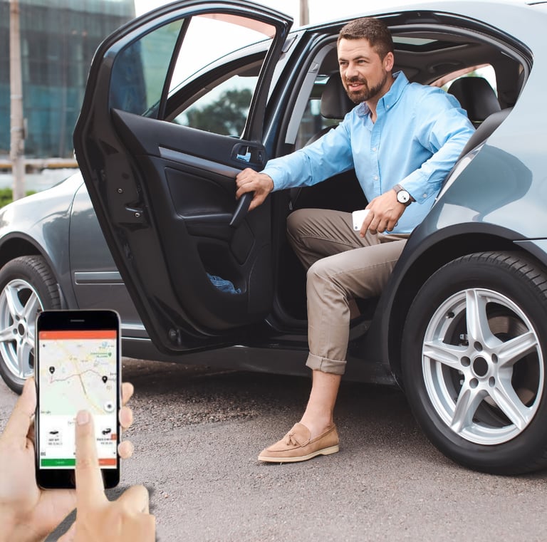 Um homem sentado em um carro com um celular na mão