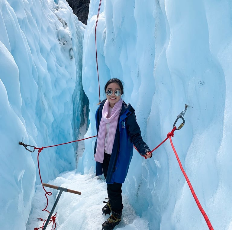 a woman in a blue jacket and pink scarf on a rope tied to a rope