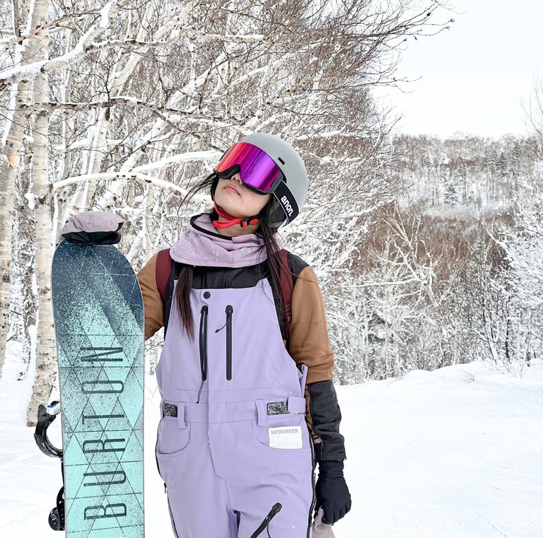 a snowboarder in a purple snowsuit and a snowboard