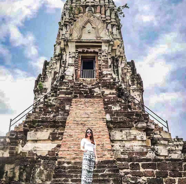 a woman standing in front of a temple with a sky background