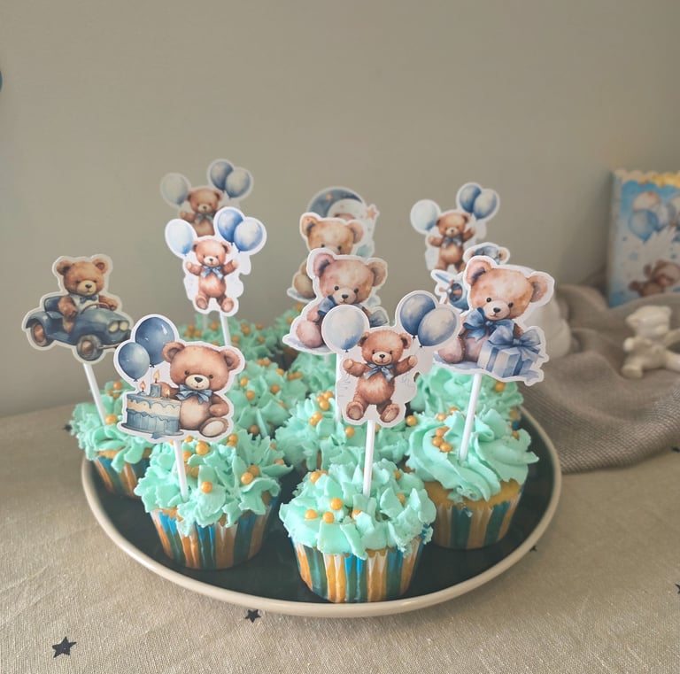 Blue teddy bear cupcakes with themed toppers for a boy baby shower or birthday party.