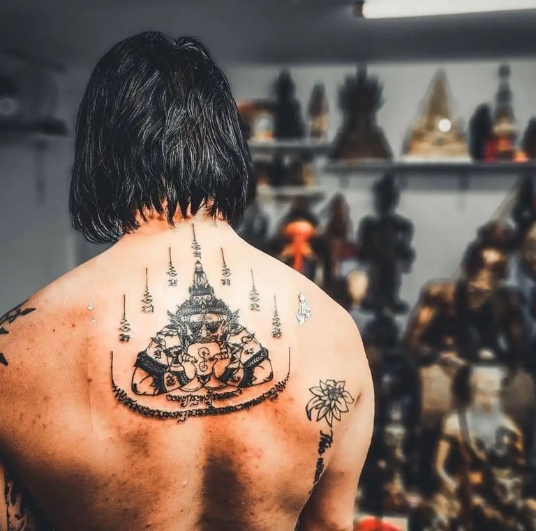 a man with a thai tattoo on his back and a tattoo on his back and traditional thai sak yant tattoo