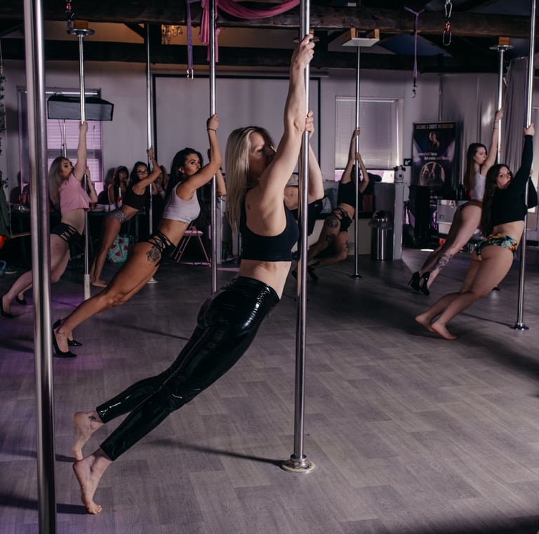 Image of Sxefit pole dancing class with all students leaning in the same pose