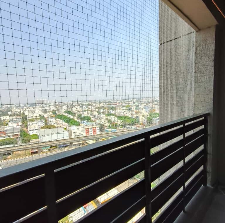 Installation team fitting a safety net on a high-rise window in Bangalore