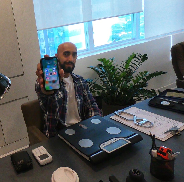a man sitting at a desk with a cell phone in his hand