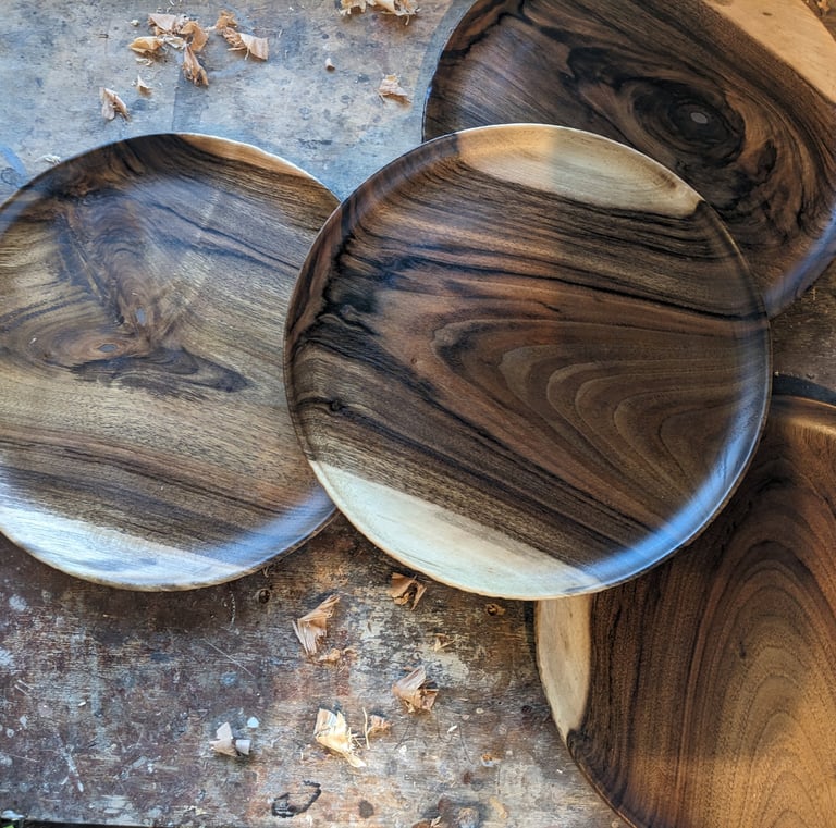 a bunch of wooden plates with wooden bowls and bowls
