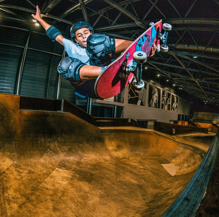 a man in a blue shirt is doing a trick on a skateboard pomge Marseille France skatepark