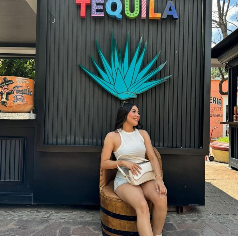 a woman sitting on a barrel chair in front of a tequila bottle