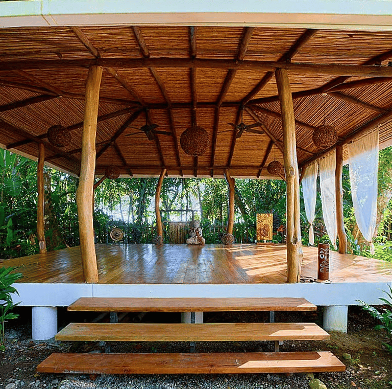Open-air wooden yoga shala in tropical forest at Rose Temple Grove, designed for feminine embodiment