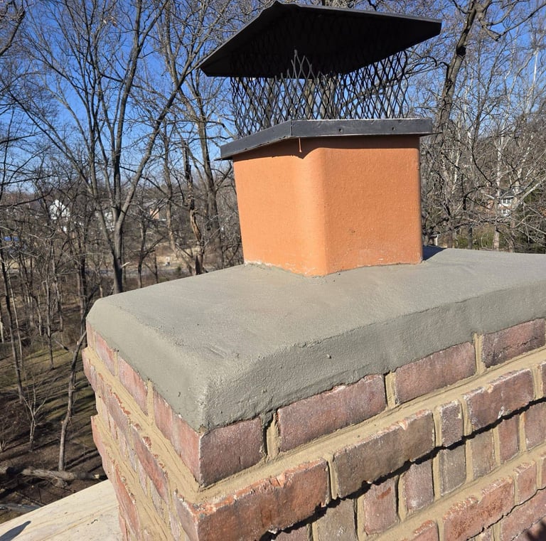 A newly installed concrete chimney crown and metal cap on a brick chimney by Roslyn Chimney