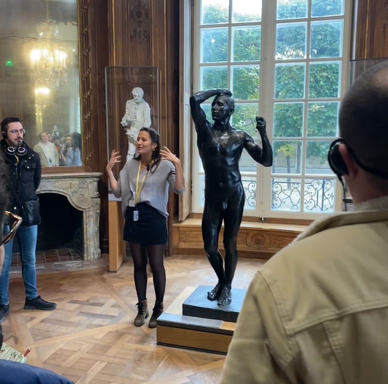 Un guide présentant la statue en bronze d’Auguste Rodin L’âge d'Airain au musée Rodin à Paris.
