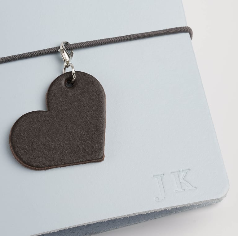 a heart shaped leather tag with a leather heart charm