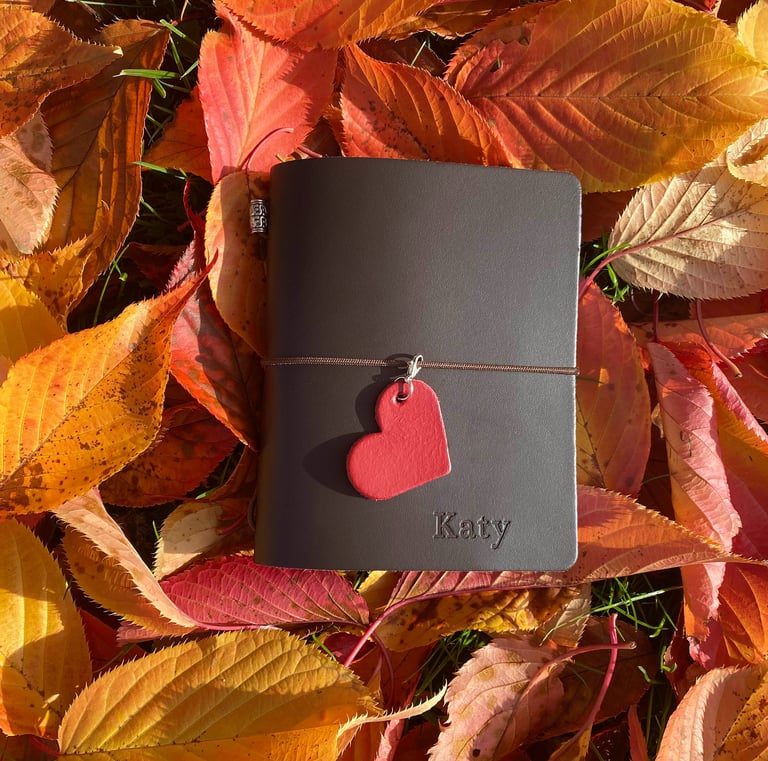 a leather journal with a heart shaped leather heart on it