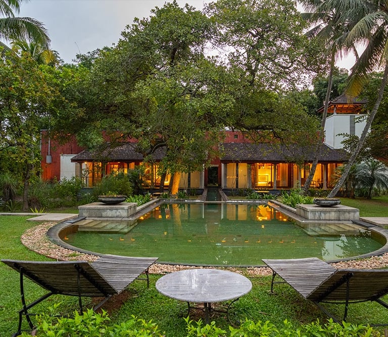 Lakeside luxury villa in Kerala, featuring a serene garden, traditional architecture.