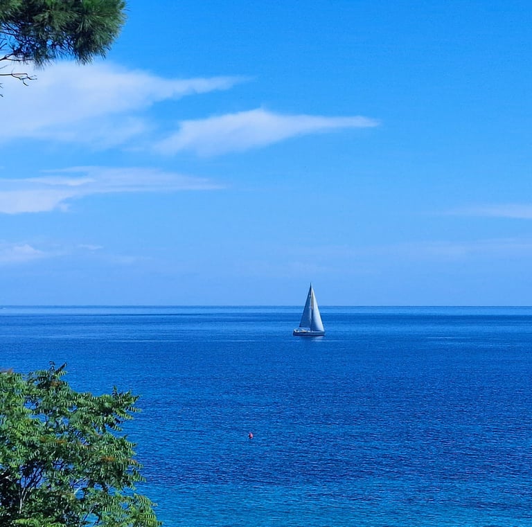 Blick auf das Boot auf See von der Terrasse des Ferienhauses
