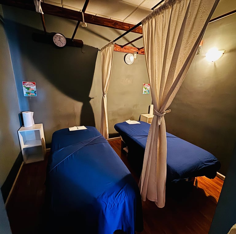 a couple of beds in a room with a curtain