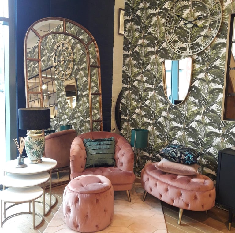 a living room with a pink arm chair and a mirror