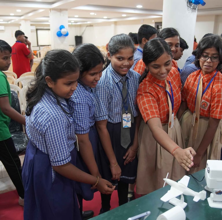 a group of people standing around a table with a cake